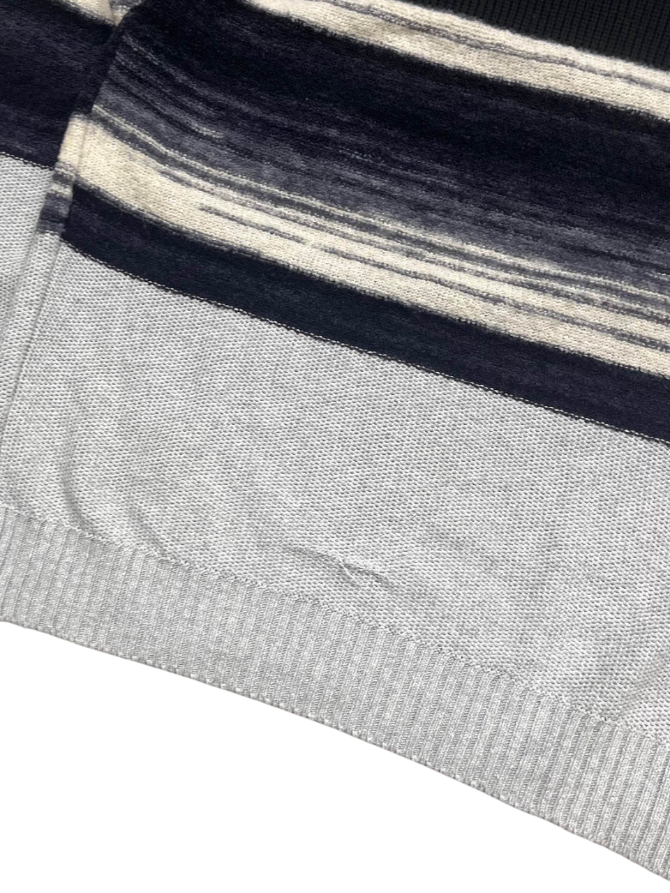 Szürke és fekete mintás streetwear pulóver alsó szegély részlet, vintage stílusban
