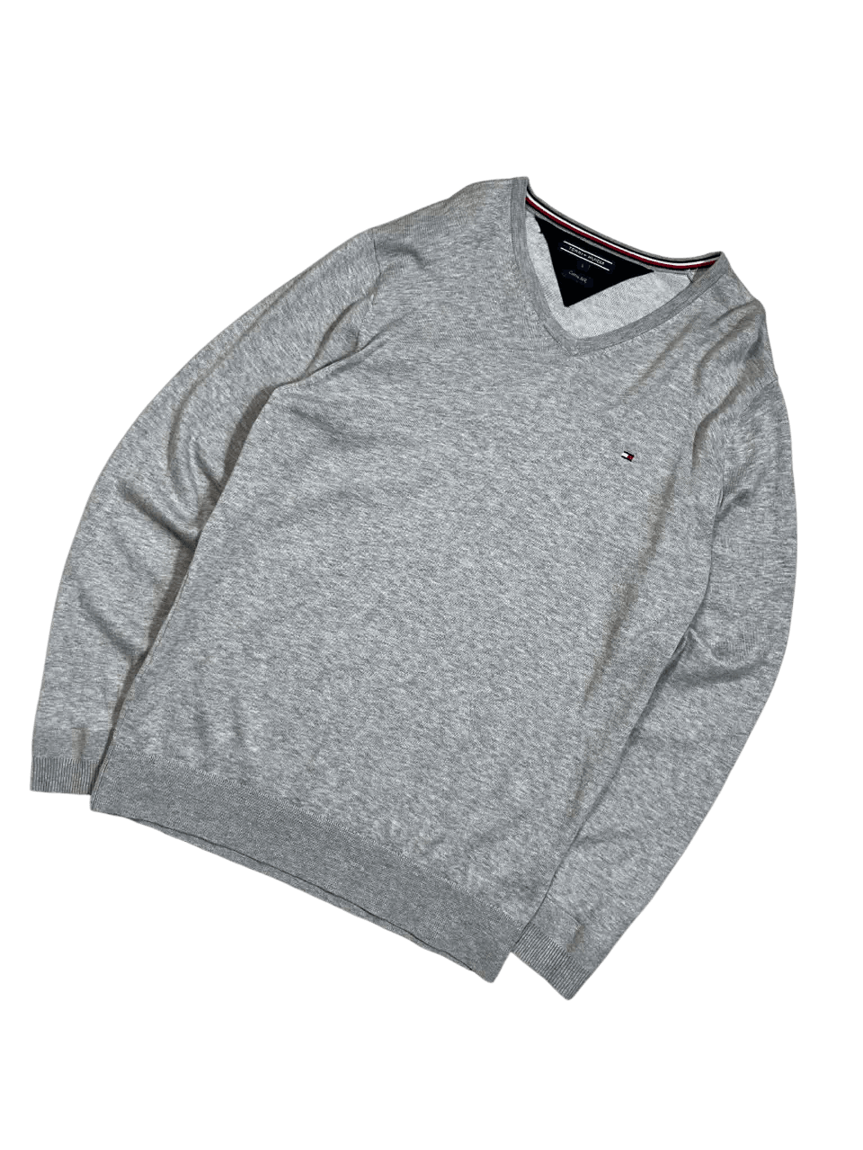 Szürke V-nyakú pulóver, hímzett logóval, vintage streetwear stílusban.