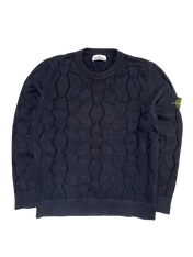 Fekete kötött pulóver jellegzetes mintával, karon logós felvarróval, streetwear stílusban.