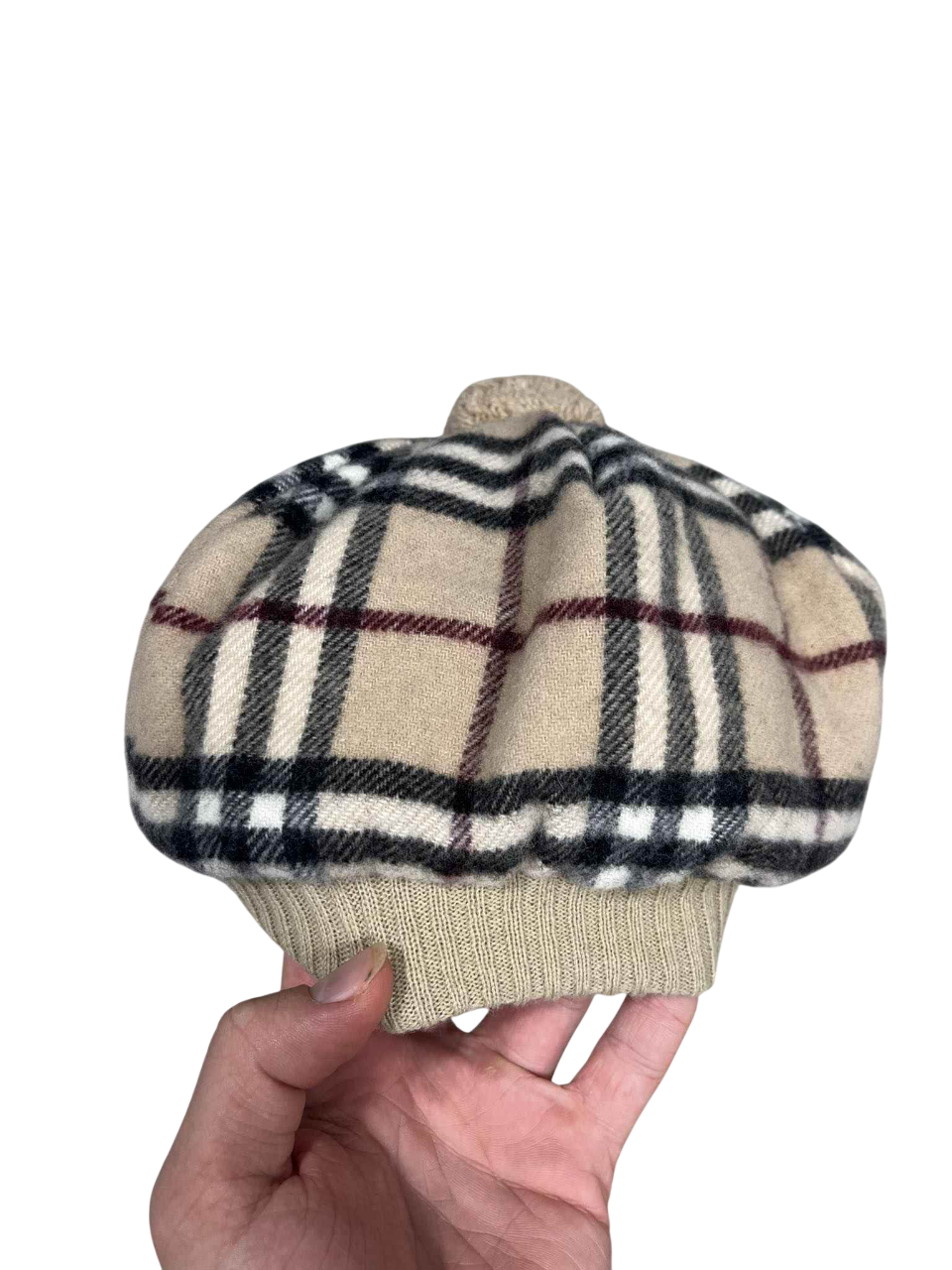 Bézs kockás mintás vintage streetwear sapka kézben, retro stílusban.