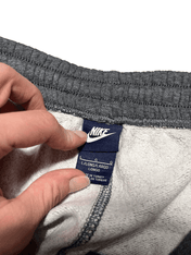 Nike vintage szürke melegítőnadrág belső címke, streetwear kézben tartva