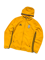 Sárga Adidas kapucnis Juventus dzseki cipzárral és fekete csíkokkal, streetwear stílusban.