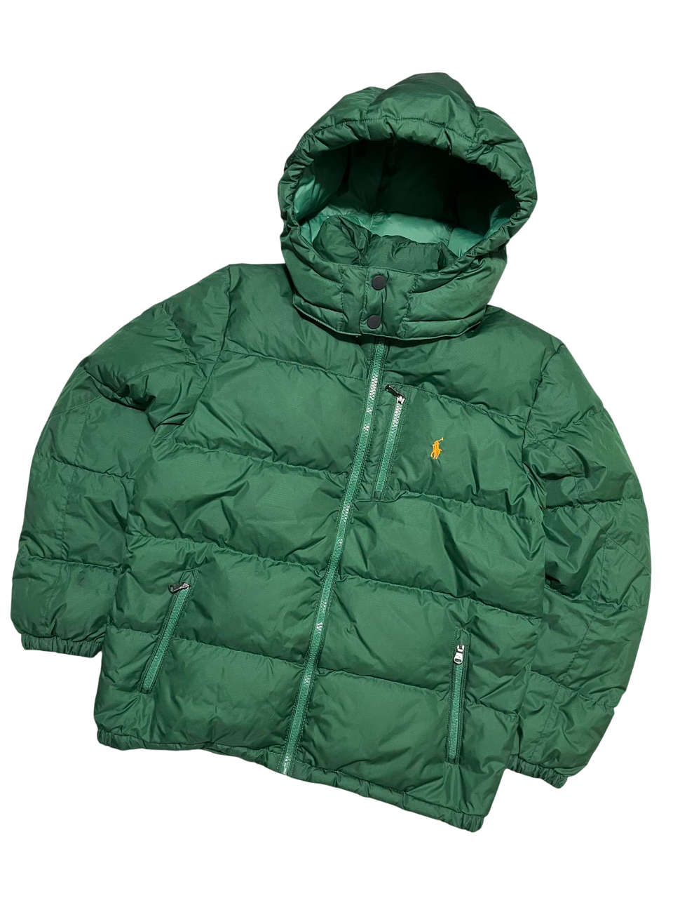 Zöld vintage pufi dzseki kapucnival és cipzáras zsebekkel, streetwear stílusban.