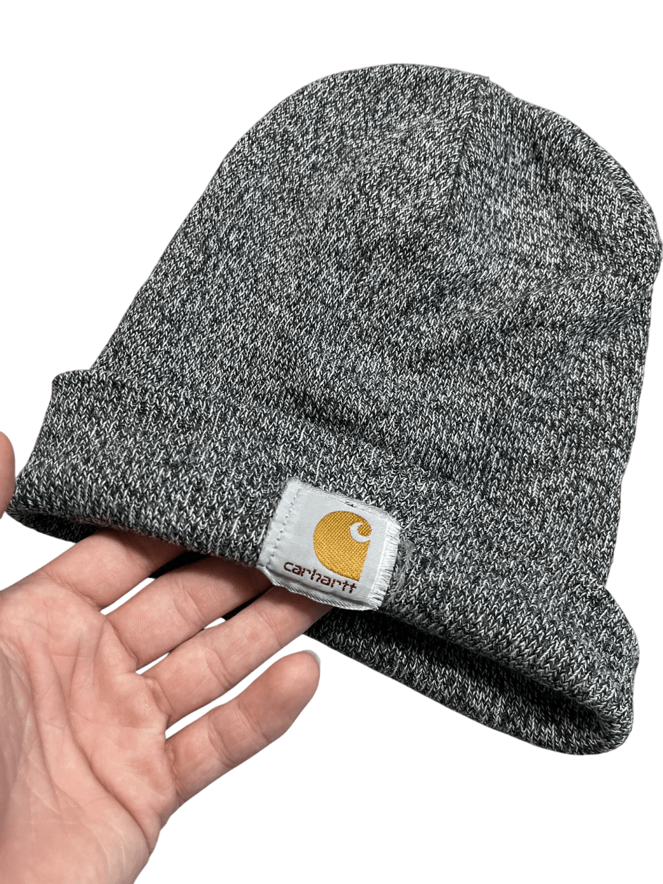 Szürke Carhartt kötött sapka kézben, streetwear stílus, márkajelzéssel az elején.