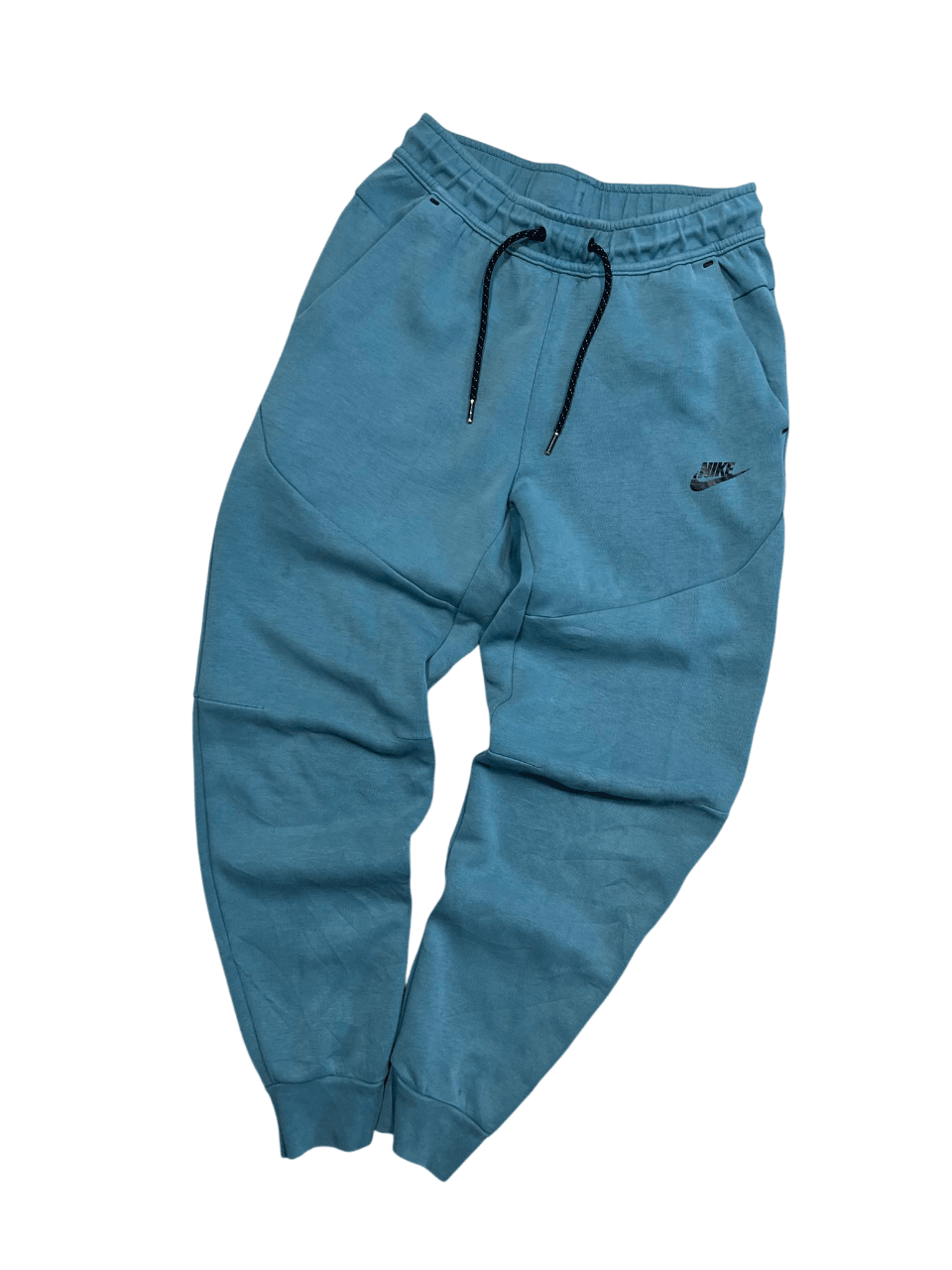 Kék Nike melegítőnadrág, streetwear stílusban, zsebekkel és gumis derékkal.
